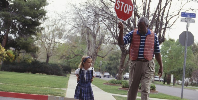 Child being escorted by crossing guard